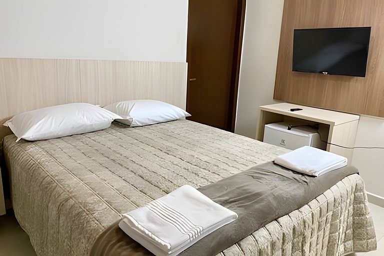 Quarto casal confortável com TV e frigobar