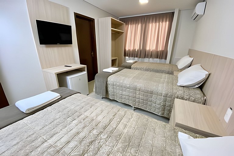 Quarto triplo confortável com TV e frigobar