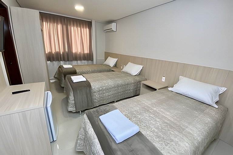 Quarto triplo confortável com TV e frigobar