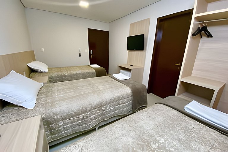 Quarto triplo confortável com TV e frigobar