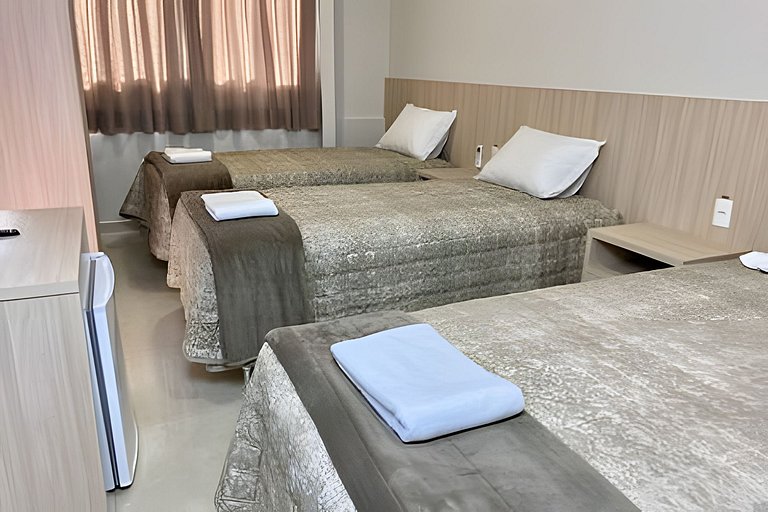 Quarto triplo confortável com TV e frigobar