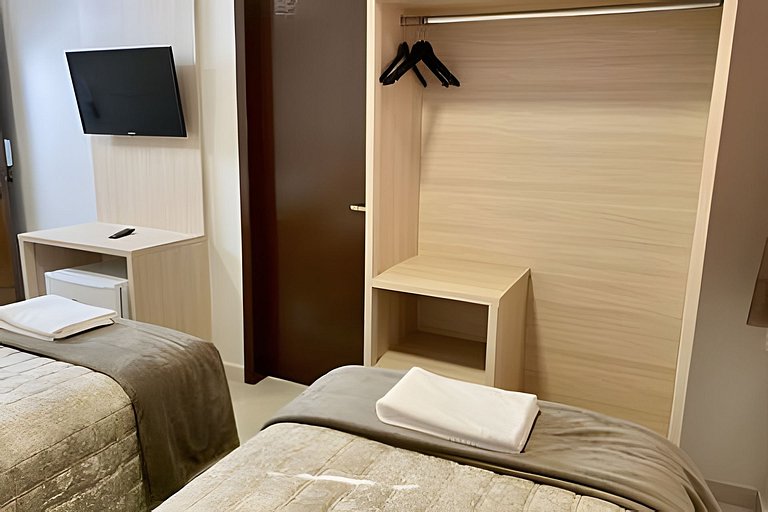 Quarto triplo confortável com TV e frigobar