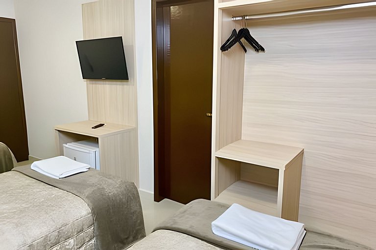 Quarto triplo confortável com TV e frigobar