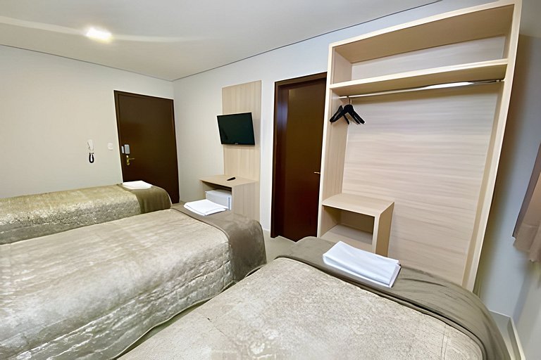 Quarto triplo confortável com TV e frigobar