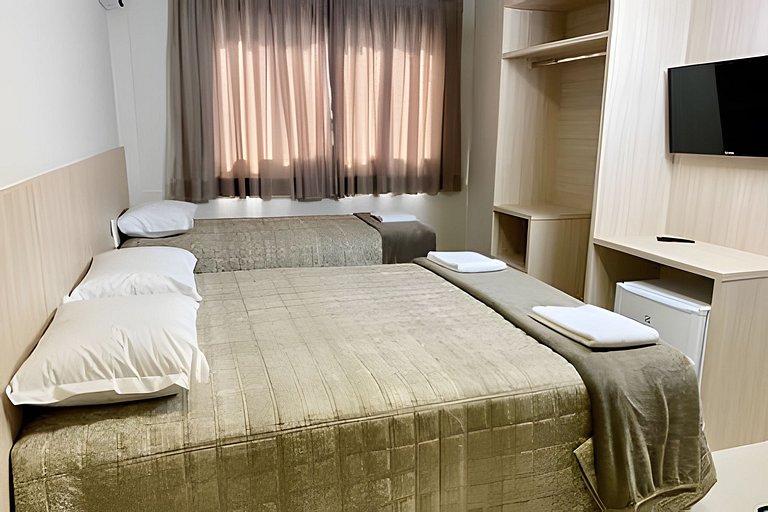 Quarto triplo confortável com TV e frigobar