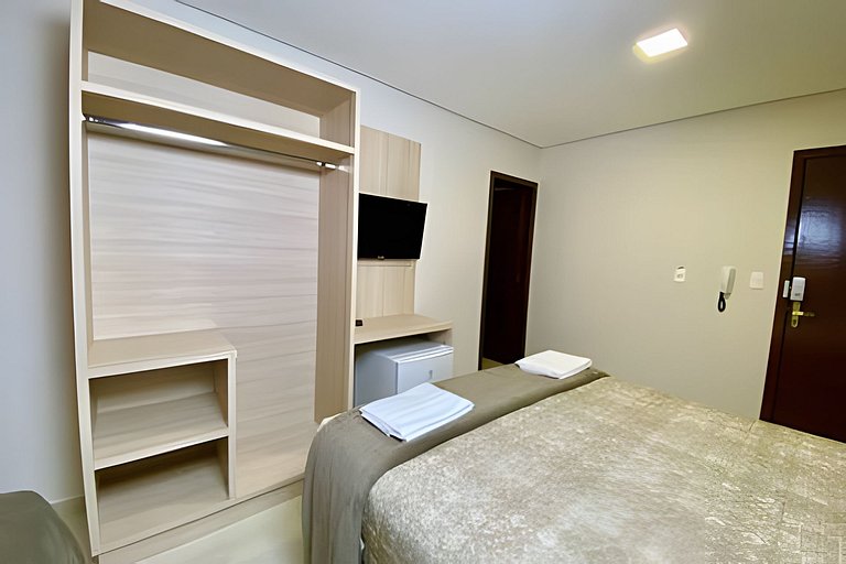 Quarto triplo confortável com TV e frigobar
