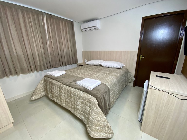 Quarto casal confortável com TV e frigobar