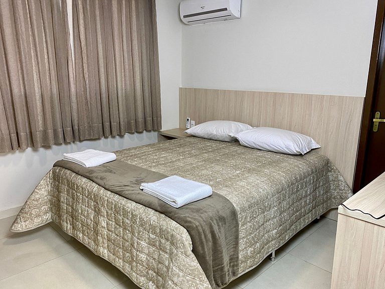 Quarto casal confortável com TV e frigobar